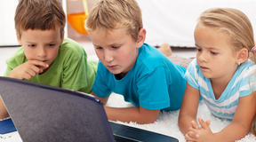 Focused kids looking at laptop computer